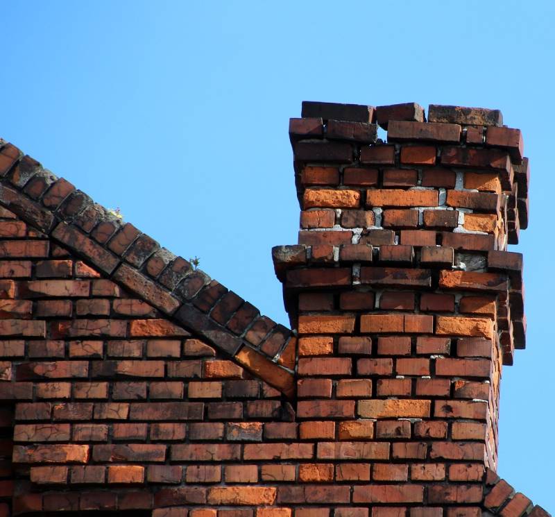 Damaged chimney on an Lathrup Village home showing cracks and missing mortar